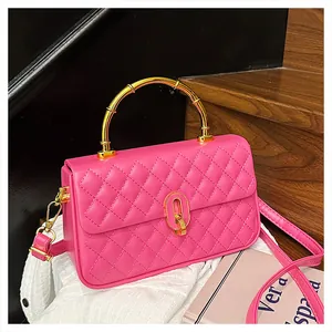 Borsa in pelle trapuntata magenta con manico in bambù dorato e tracolla su fondo bianco