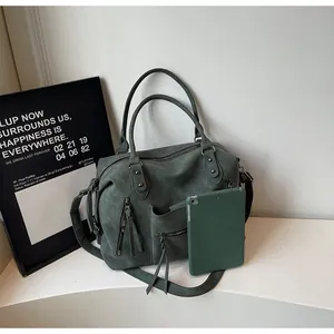 Detail of vintage matte green tote bag showing tassel zippers and multi-pocket layout