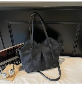 Detail of dark grey frosted tote bag with adjustable buckle strap and side pleats