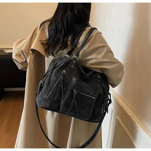 Detailed back view of vintage charcoal leather tote bag with long tassel zippers