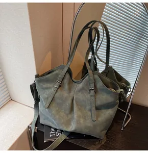 Detail of dark green tote bag with matte texture and dual adjustable shoulder straps