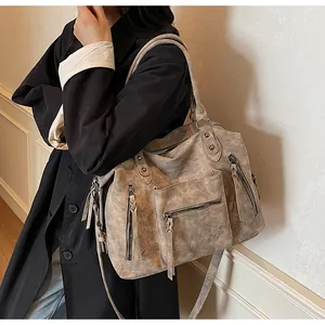 Detail view of large vintage grey tote bag with tassel zippers and crossbody strap