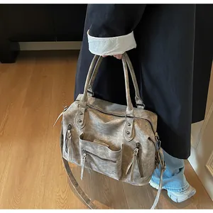 Detail of vintage gray faux leather tote bag with functional pockets and long shoulder strap
