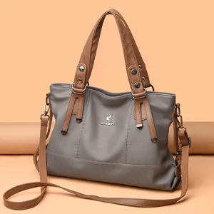 Grey pebbled leather crossbody tote bag with brown handles and silver-tone hardware