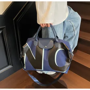 Detail of blue canvas travel bag with NO print and leather handle on stairs