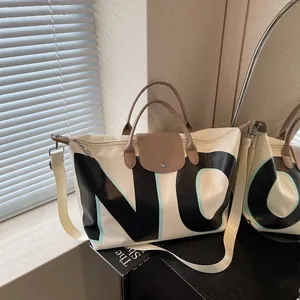 Large capacity cream travel tote with brown leather handles and bold 'NO' letter print