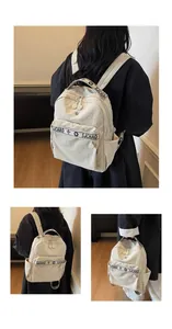 Close-up of beige travel backpack featuring durable nylon fabric and branded SJCHAO straps