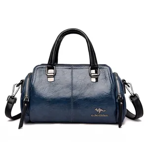Bolso Boston retro azul con asas negras y logo de canguro metálico en el frente