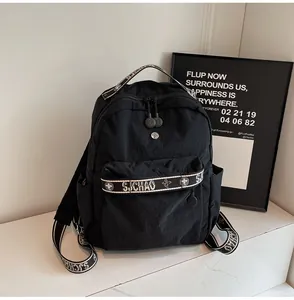 Detail of minimalist black travel backpack featuring stylish patterned shoulder straps