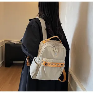 Detail of beige nylon backpack featuring orange SJCHAO straps and stylish side pockets
