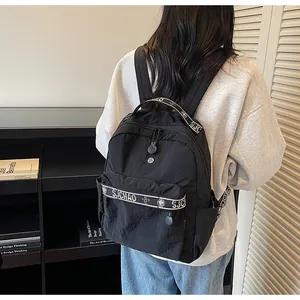 Side view of black nylon backpack with decorative branded straps for travel or school