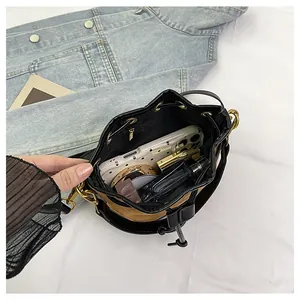 Détail de l'intérieur du sac seau montrant le rangement spacieux pour téléphone et maquillage