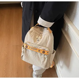 Detail of beige nylon backpack with orange SUCHAO embroidered straps and side pockets