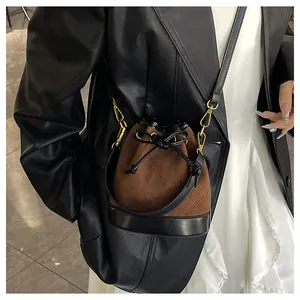 Détail du sac seau bandoulière avec texture treillis en daim marron et cordon de serrage