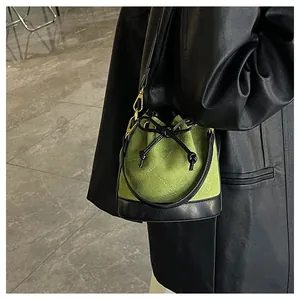 Détail du sac seau vert avocat avec motifs matelassés et un nœud coulissant noir