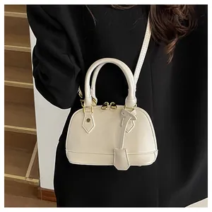 Dettaglio borsa a conchiglia bianco panna con pelle grana litchi e zip dorate eleganti