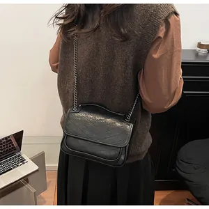Dettaglio della borsa a tracolla trapuntata nera con catena e cuciture a forma di V eleganti