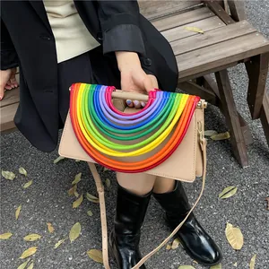 Detail der beige Kunstledertasche mit buntem Regenbogen-Dekor und goldener Hardware