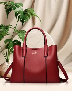 Détail du sac à main en cuir de vachette rouge foncé avec logo kangourou doré