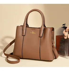 Détail du sac cabas marron foncé avec texture grainée de qualité et logo doré