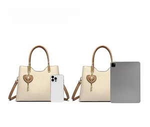 Size comparison of beige crossbody bag with brown handle against iPad and iPhone