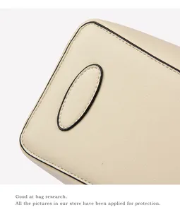 Close-up of cream faux leather handbag with grainy texture and premium stitching