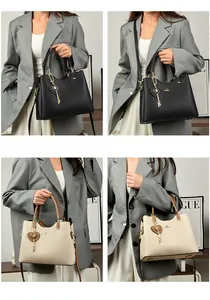 Detail view of large tote bag with kangaroo logo and heart charm in black and beige