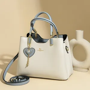 Elegant white and blue leather handbag with gold hardware and shoulder strap