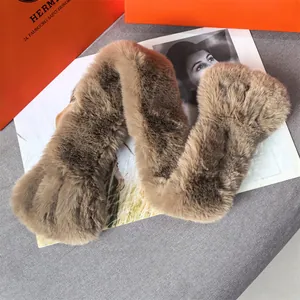Close-up of thick brown faux fur scarf with soft texture on a grey fabric background