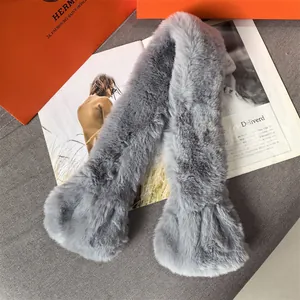 Close-up of the plush faux fur texture on a light gray scarf with premium packaging