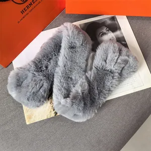 Close-up of plush grey faux fur scarf texture next to high-end fashion magazine