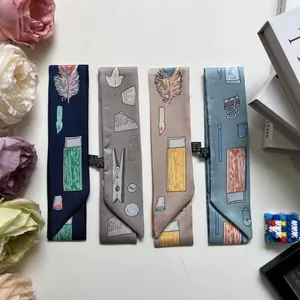Vue macro de quatre écharpes en satin imprimées avec des motifs de papeterie sur table