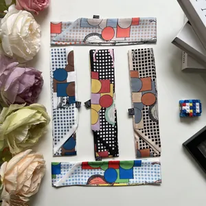 Dettaglio di 5 sciarpe in seta sintetica con motivi geometrici e pois per manici di borse