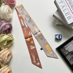 Gros plan d'un foulard Twilly double face avec motifs vintage posé sur un livre