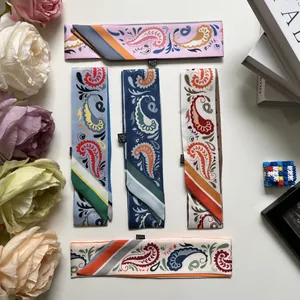 Detailed view of paisley pattern twilly scarves with vibrant contrast stripe designs
