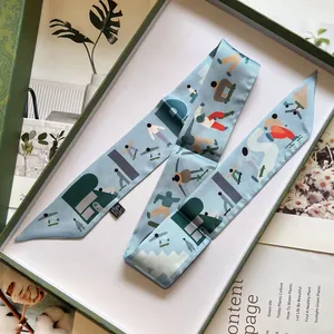 Détail d'un foulard en soie bleu clair avec motifs de sport dans une boîte cadeau