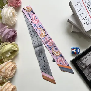 Close-up of double-sided paisley and cheetah print silk ribbon scarf on white background