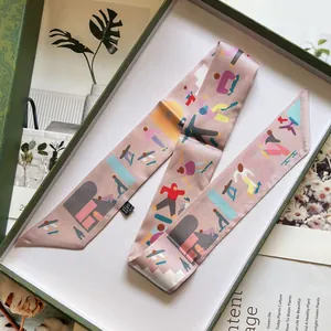 Vue détaillée du foulard Twilly rose imprimé élégamment placé dans un coffret cadeau