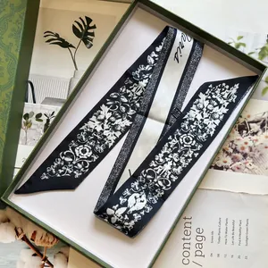 Detailed shot of floral print silk scarf with Paris lettering in premium gift box