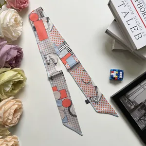 Vista dettagliata di un foulard sottile in raso con stampe di cavalli e geometrie
