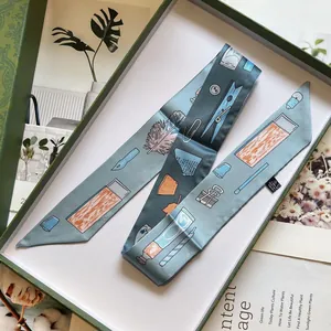 Détail du foulard étroit artistique en imitation soie placé dans son coffret cadeau vert