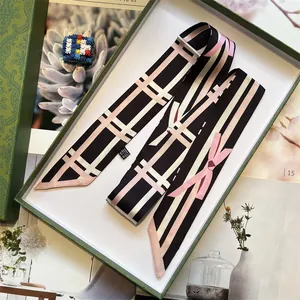 Elegant geometric stripe silk-like twilly scarf with pink bow print on a green gift box