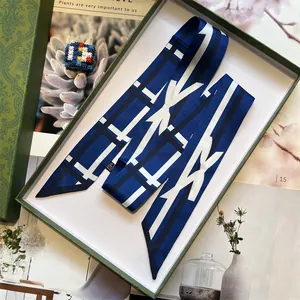 Elegant navy blue geometric twilly silk scarf presented in a luxury green embossed gift box