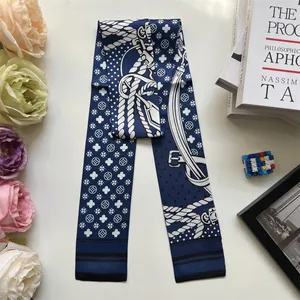 Close-up of navy blue satin skinny scarf with white nautical ropes and geometric patterns