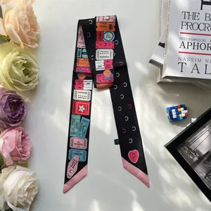 Detail of a black patterned narrow scarf with vintage fashion ticket prints and pink tips