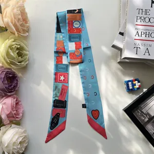 Detailed view of a light blue silk twilly scarf with retro ticket print on a book