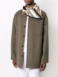 Détail d'un foulard en soie de 55cm avec imprimé équestre porté sur une tenue chic