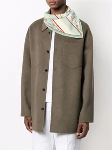 Détail d'un carré de soie à motif équestre porté avec une veste en laine marron
