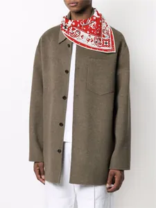 Styling detail of a red paisley silk scarf paired with a brown wool coat for autumn