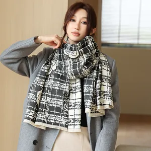 Detail of black and white scarf featuring floral rose patterns and frayed edges